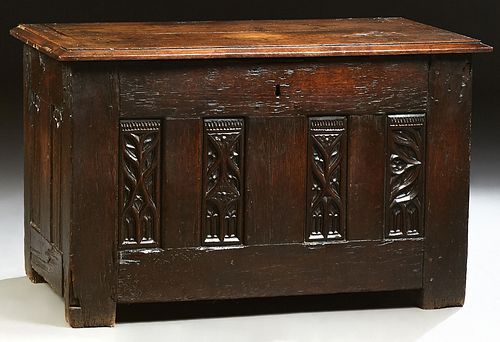 French Provincial Carved Oak Coffer, 19th c., the stepped slanted edge top over four relief Gothic carved panels, flanked by linen f..