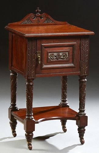 English Carved Mahogany Nightstand, early 20th c., with an arched finialed back on a stepped top, over a cupboard door on twist carve..