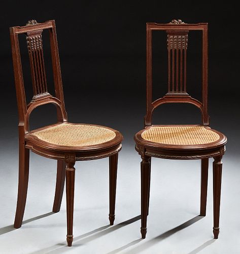 Pair of Louis XVI Style Carved Mahogany Side Chairs, 19th c., each with a floral carved crestrail, vertical pierced back splat above...
