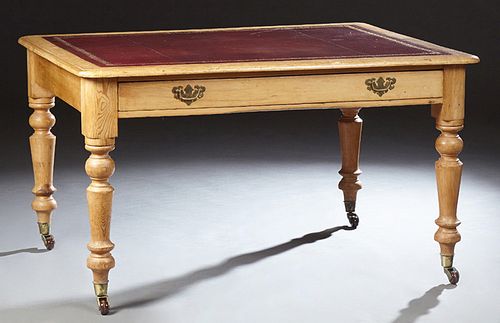 English Carved Pine Writing Table, 19th c., the rounded edge and corner top with an inset gilt tooled leather top, over a long friez..