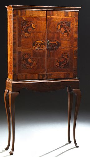 Queen Anne Marquetry Inlaid Walnut Cabinet on Stand, 18th c., the ogee crown over double doors intricately inlaid with parrots and f...