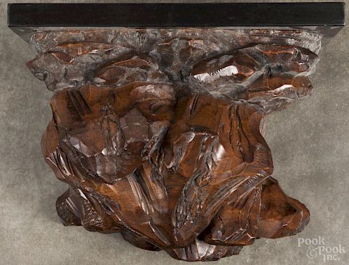 Black Forest carved wall shelf with a later ebonized top, 10 1/2'' h., 13 1/2'' w.
