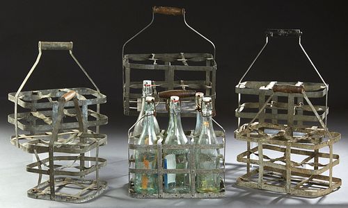 Group of Six French Provincial Strap Iron Wine Bottle Carriers, late 19th c., each with a wooden handle and designed to hold six win...