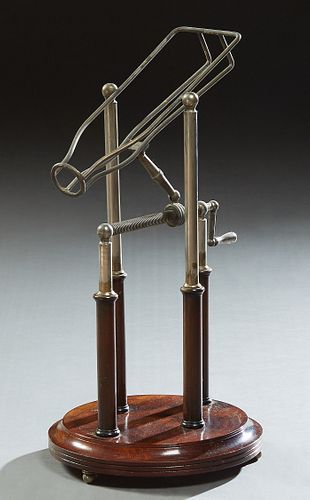 A Metal French Style Mechanical Wine Bottle Pourer, 20th c., on a circular stepped mahogany stand, on brass ball feet, H.- 18 1/2 in...