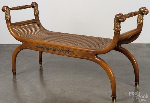 French fruitwood window bench, 20th c., with a caned seat and painted lion head terminals, 28'' h.