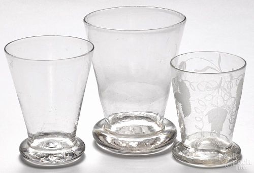 Three blown colorless glass drinking vessels, one with etched decoration, tallest - 5 5/8''.