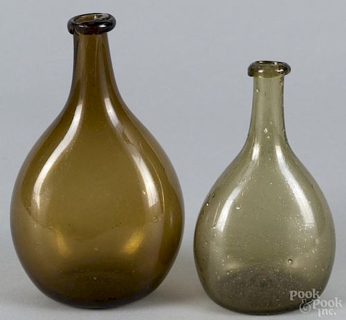 Amber and green blown glass bottles, 6'' h. and 7'' h. Provenance: DeHoogh Gallery, Philadelphia.