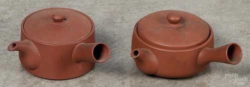 Two Japanese Tokonome-ware red clay teapots or kyusu with side handles, decorated with characters