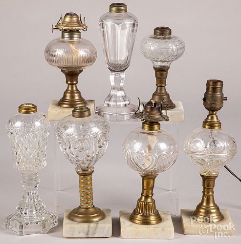 Seven colorless glass fluid lamps.
