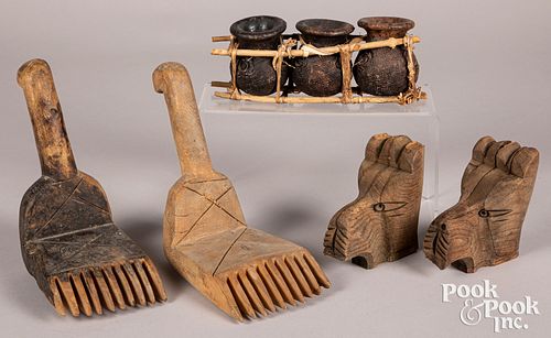 Three carved ceramic pots in twig brace