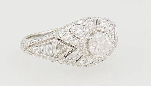 Lady's 18K White Gold Dinner Ring, with a .72 ct. round diamond within an arched top tapered band mounted with round diamonds, the shoulders mounted w