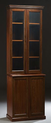 English Carved Mahogany Slender Bookcase Cupboard, early 20th c., the stepped crown over a double glazed door bookcase, on a stepped base with double 