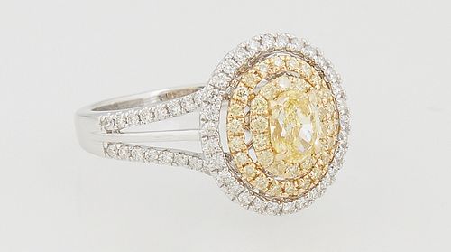 Lady's 18K White Gold Dinner Ring, with an oval .45 ct. fancy yellow diamond, atop a pierced double concentric graduated border of round yellow diamon