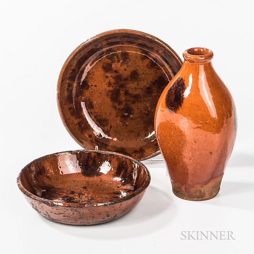 Redware Flask and Two Small Redware Dishes, 19th century, the flask with red-orange glaze and three manganese splotches, the plates wit