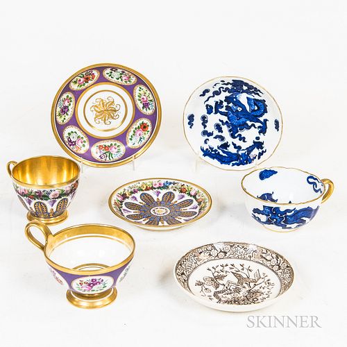 Three Porcelain Cups and Four Saucers, including a Sevres gilt and floral-decorated set and a Coalport blue and white cup and saucer.