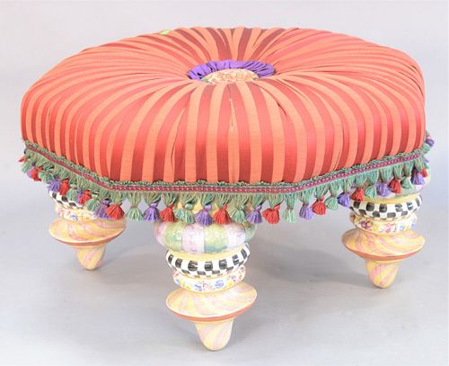 Large red upholstered Mackenzie Childs ottoman, with hand painted ceramic feet, 21" x 33".