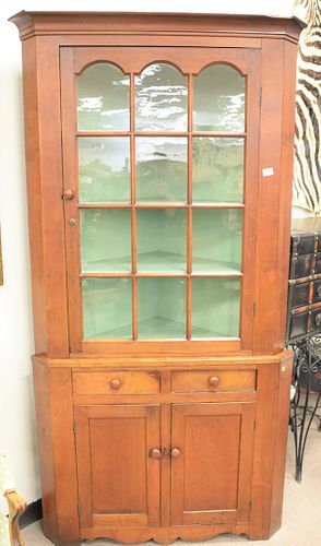Primitive cherry two-part corner cabinet, glazed door top over two drawers and two door base, green painted interior, ht. 83", wd. 43", dp. 28 1/2".