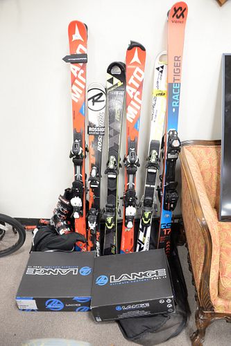 Group of children's snow skis, boots and poles, brands include Atomic, Lange and Fischer, varying sizes.