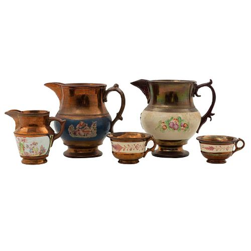 Lote de 5 piezas. Siglo XIX. Elaborados en cerámica con esmalte "Copper Luster". Consta de: cremera, 2 tazas y 2 jarras.