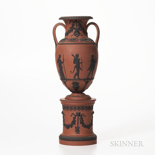 Wedgwood Rosso Antico Vase on Drum Base, England, early 19th century, applied black basalt relief, the vase with trophies and palmettes
