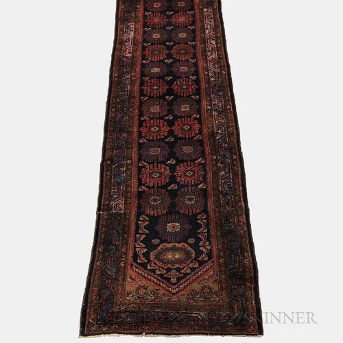 Malayer Runner, Iran, c. 1920, featuring a dark blue field with stylized palmettes, 14 ft. 2 in. x 3 ft. 3 in.