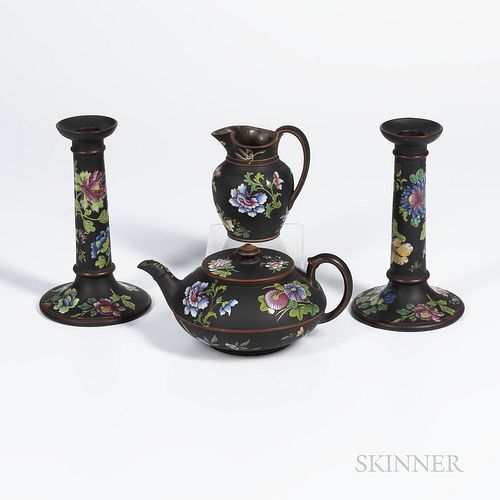 Four Wedgwood Enamel Decorated Black Basalt Items, England, 19th century, each with polychrome enameled flowers, a pair of candlesticks