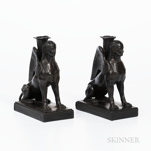 Pair of Wedgwood Black Basalt Seated Sphinx Candleholders, England, each modeled with a foliate molded candle nozzle set between their