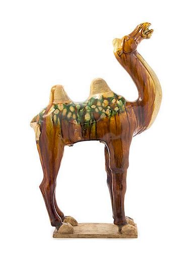 A Sancai Glazed Pottery Figure of a Camel TANG DYNASTY Height 22 3/4 inches.