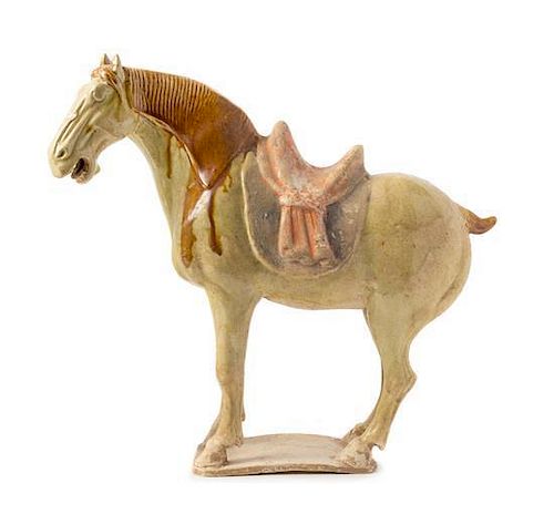 A Straw Glazed Pottery Figure of a Caparisoned Horse TANG DYNASTY Height 12 7/8 inches.