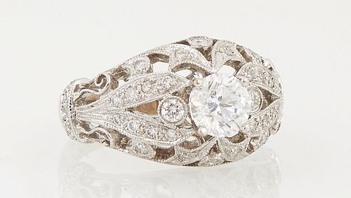 Lady's 18K White Gold Dinner Ring, with a central .71 ct. round diamond, atop a tapered diamond mounted cutout band, with diamond mo...