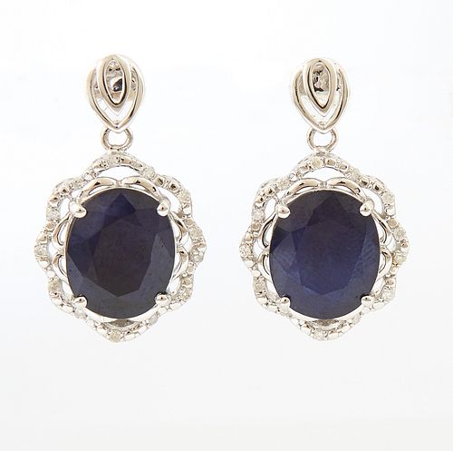 Pair of 14K White Gold Pendant Earrings, each with a pierced double pear shaped stud and a pendant 6.28 ct. oval blue saphire within...