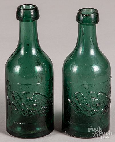 Two embossed eagle blob top green soda bottles