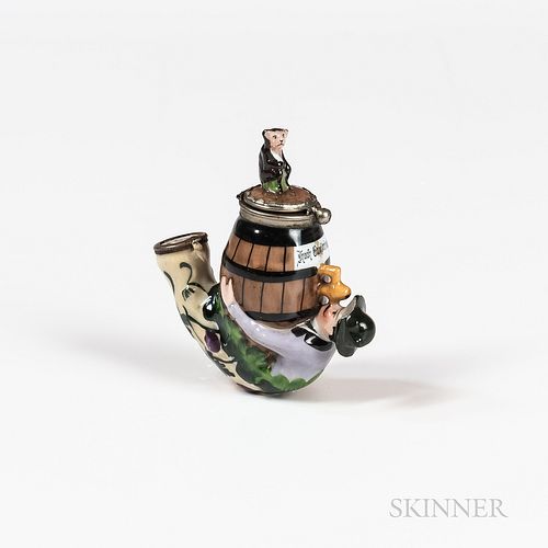 Porcelain Figural Pipe Bowl, featuring a man clutching a keg, atop which a monkey sits.