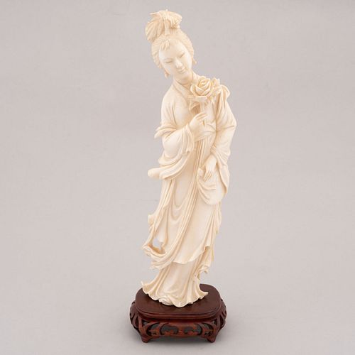 Guan Yi. China. Siglo XX. En talla de marfil. Con base de madera tallada. 25 x 7 x 4 cm
