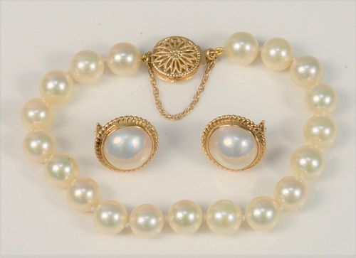 Three Piece Pearl Suite 
to include 14 karat gold clasp, and pair pearl earrings, set in 14 karat gold 
length 7 inches
8.6 millimeters