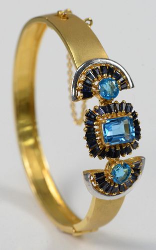 22 Karat Gold Bangle Style Bracelet
set with three blue topaz, surrounded by blue sapphires
32 grams total weight