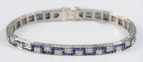 Platinum Diamond Bracelet
set with thirty-four diamonds, surrounded by Greek key design, with square blue sapphires, (one small sapphire missing),
Pat