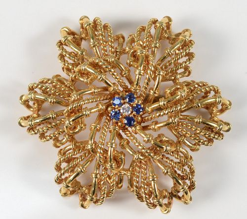 Tiffany & Company 18 Karat Gold Brooch
set with five blue sapphires, and one diamond
diameter 2 inches
35 grams