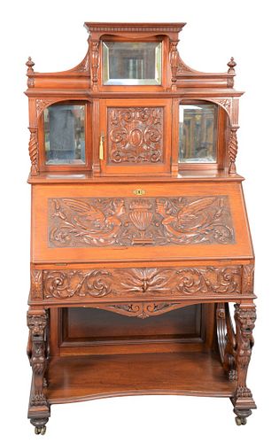 Victorian Mahogany Desk
having mirrored back, with door over carved drop lid, over carved drawer, all set on winged griffin supports, on shelf with tu