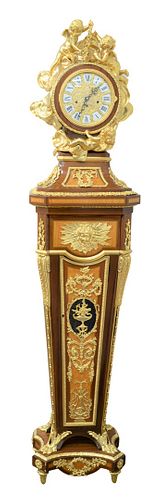 Regency Style Tall Case Clock
having gilt bronze puttis surrounding circular dial on inlaid and gilt bronze case, base with round legs ending in paw f