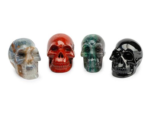 A Set of Four Carved Agate, Fluorite, Red Jasper and Black Obsidian Skulls