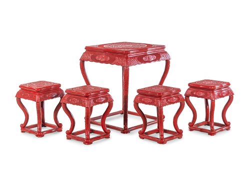 A Chinese Export Carved Red Lacquer Game Table and Four Stools