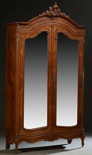 French Carved Mahogany Louis XV Style Armoire, early 20th c., the arched crown with a central pierce C-scroll Crest, over double beveled mirror doors,