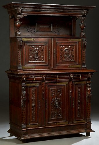 Henri II Style Carved Oak Sideboard, c. 1880, the stepped edge crown over two relief carved soldiers' heads over an open shelf, above double relief ca