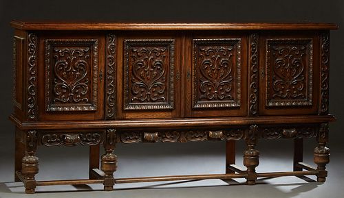 Spanish Renaissance Style Carved Oak Sideboard, early 20th c., the stepped ogee edge top over two setback cupboard doors with applied scroll and flora