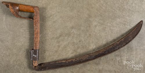 Unusual iron scythe with carved handle