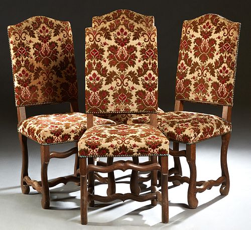 Set of Four Louis XIV Style Carved Beech Dining Chairs, 20th c., the arched canted cushioned backs to trapezoidal cushioned seats, on serpentine legs 