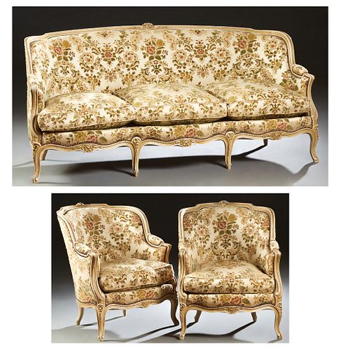 French Three Piece Polychromed Carved Beech and Oak Parlor Suite, 20th c., consisting of two bergeres and a settee, the serpentine floral carved crest
