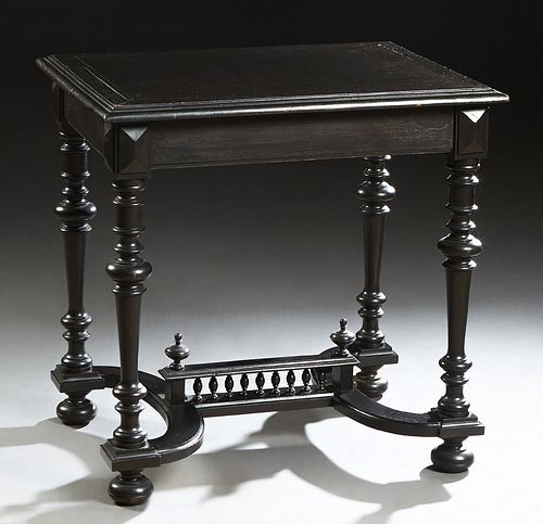French Henri II Style Carved Ebonized Walnut Writing Table, c. 1880, the stepped rectangular top over a wide skirt, on turned tapered legs, joined by 