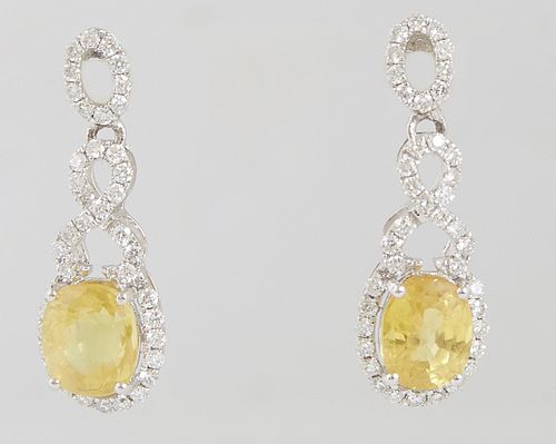 Pair of Platinum Pendant Earrings, with pierced oval diamond mounted studs, to an infinity bail and a pendant with a 2.14 carat oval yellow sapphire a